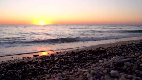 4k video. Waves on the beach with pebbles at sunset, the sun goes into the water 스톡 동영상 161806223