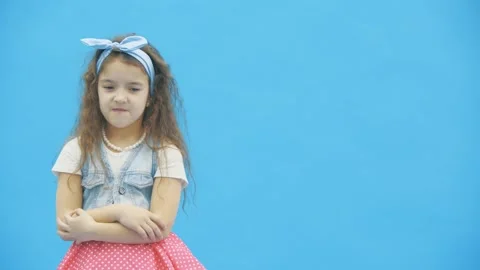 4k video where little girl showing thumbs down over blue background. Stock Footage
