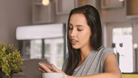 4k video of woman using tablet computer touchscreen in coffee cafe. Stock Footage 201094331