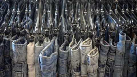 4k view of the alignment of a number of jeans hanging on hangers. Stock Footage 114295051