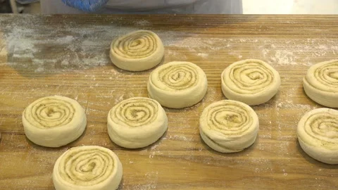 4K view of baker hands shape buns for baking on wooden table Stock Footage 112915951