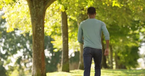 4K View from behind happy energetic man jumping &amp; clicking his heels in forest Stock Footage 81845213