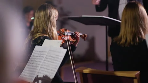 4K View from behind orchestra violinists with conductor in background Stock-Footage 68680141