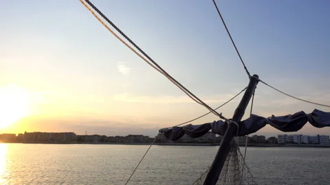 4K view of the bow and mast of a ship with folded sail in motion at sunset Stock Footage 114294388