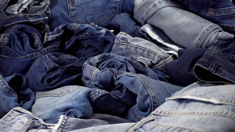4K view of a bunch of trendy blue denim trousers or jeans Stock Footage 86302916