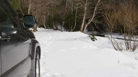 4K view by car in a valley full of snow, river that crosses the valley. Video stock 211712351