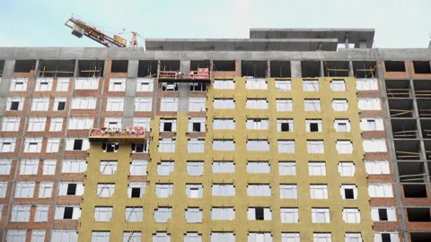 4K view of the construction hoists with workers on the facade Stock Footage 113351764