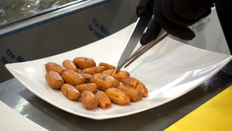 4K view of cook's hand cuts fried carrot into pieces on a plate. Stock Footage 101828097