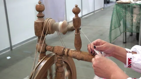 4K view of female hands spin a woolen thread on an old wooden spinning wheel. Stock Footage 88548552