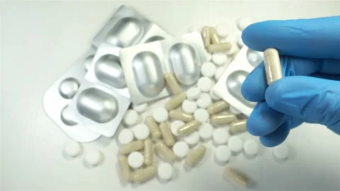 4K view of a hand in a glove taking a pill Stock Footage 145763365