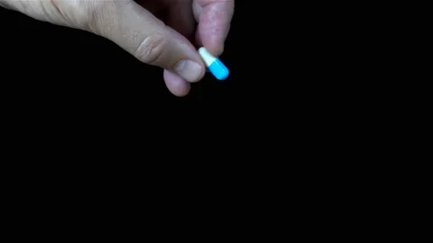 4K view of a hand holding a pill and dropping it. Stock Footage 136543206