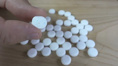4K view of hand holding tablet among white pills Stock Footage 140165715