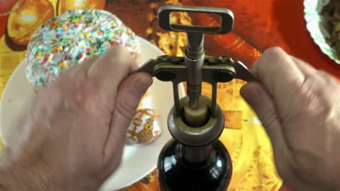 4K view of a hand opening a bottle of wine and Easter cake and eggs. Stock Footage 129009087