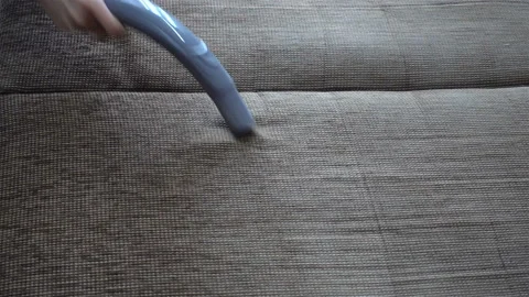 4K view of a hand vacuuming of a sofa. Stock Footage 129007192