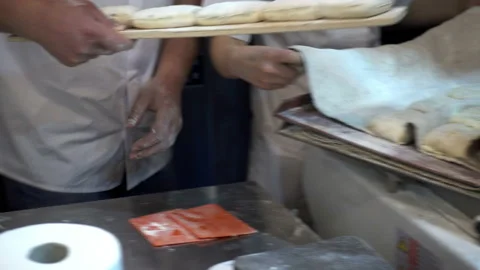 4k view of the hands of a baker spreading formed buns of dough Stock Footage 116269242