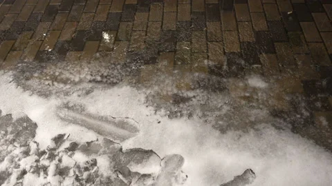 4K view of ice and snow melting on the sidewalk Stock Footage 164372360