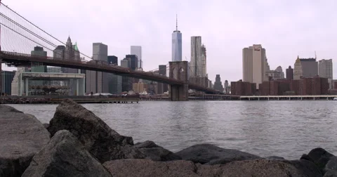 4K - View of Manhattan, Brooklyn Bridge &amp; East River from rocky Dumbo Beach Vidéo 48836343