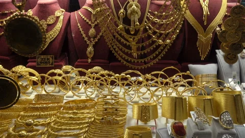 4K view of many gold bracelets and hanging necklaces Stock Footage 125758018