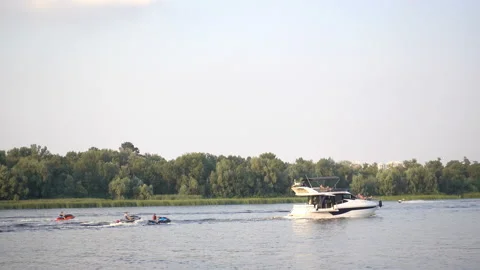 4K view of the motor yacht pulling water scooters in tow. Stock Footage 236920244