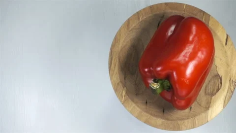 4K view of one red bell pepper rotating on plate on white Stock Footage 139562755