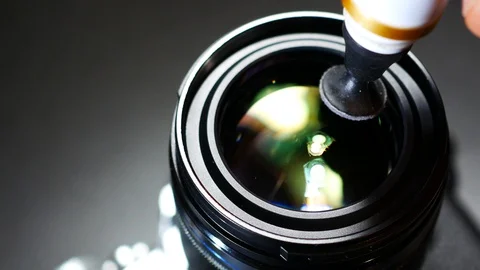 4K view of a photographer cleaning camera front lens with a lens pen brush. Stock Footage 129059189