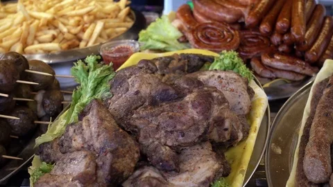 4k view of pieces of fried meat, potatoes and other food of street food stalls Stock Footage 84474237