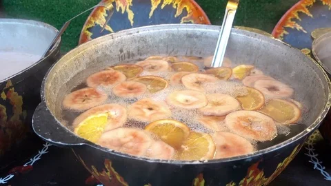4K view of pieces of fruit in mulled wine in a large cauldron Stock Footage 84476785