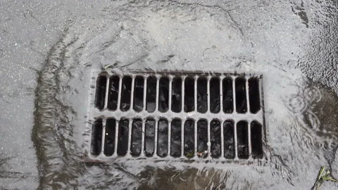 4K view of rain pouring onto a road drain Stock Footage 141338384