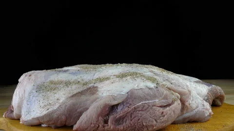 4K view of a raw piece of meat sprinkled with spices for cooking. Stock Footage 233027146