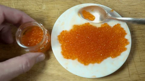 4K view of red caviar is put in a jar with a spoon Stock Footage 132100162