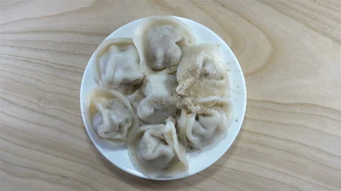 4K view of rotating dumplings on a plate with spices Stock Footage 141543661
