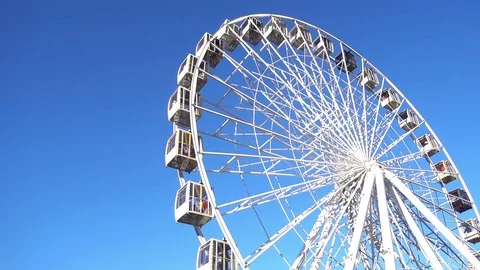 4k view of rotation of a ferris wheel against a blue sky background Stock Footage 84544198