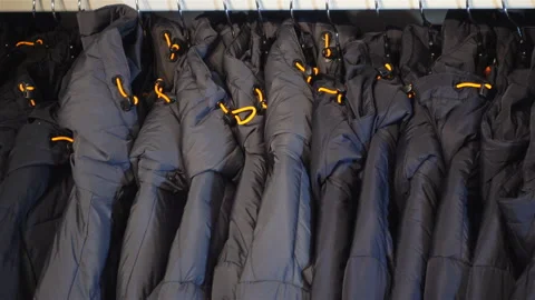4k view of a row of men's jackets. Hand takes off jacket. Stock Footage 117342885