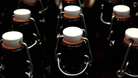 4K view of rows of dark glass bottles with lids close up Stock Footage 86674494