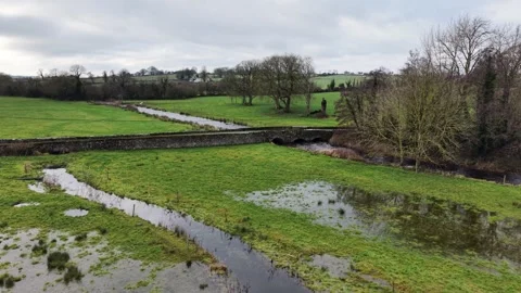 4K View of Rural Stream Flowing Through Green Fields Stock Footage 332803185