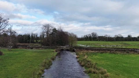 4K View of Rural Stream Flowing Through Green Fields Stock Footage 332803237