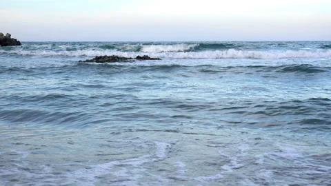 4K view of the sea waves through a small stone reef on a sandy beach. Stock Footage 93156131