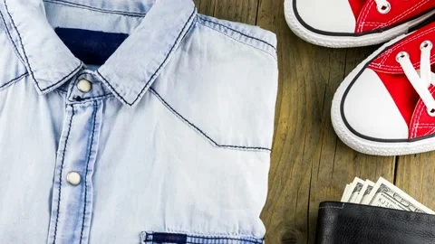 4K view of a set of male items from a denim shirt with red sneakers Stock Footage 233456373