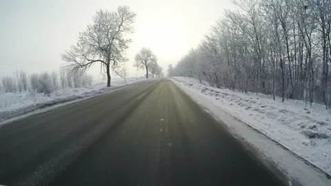 4k. View from the side of the car, the vehicle driving on a snowy road. Video stock 211707456