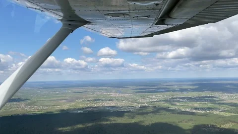 4K View from small airplane flying in clouds over forest and city Video stock 154761978