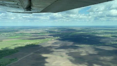 4K View from small plane flying in clouds over forest and city Stock Footage 155587024
