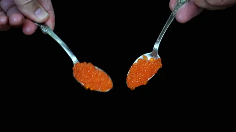 4K view of two spoons with red caviar on a black Stock Footage 136507746