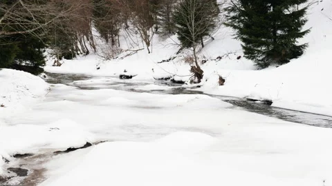 4k view of a valley through which a small mountain river flows in winter 動画素材 211711523