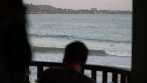 4K view of waves and surfers in the ocean from rooftop cafe bar Stock Footage 135768569