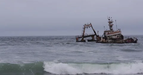 4K view of waves washing over shipwreck on the skeleton coast of Namibia Stock Footage 64697656