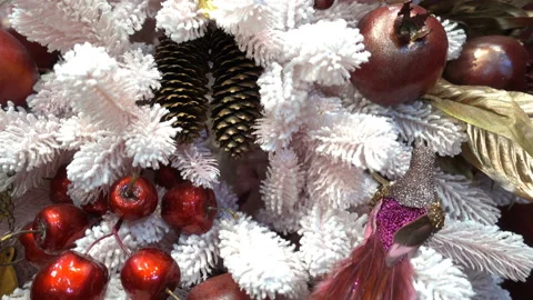 4K view of a white Christmas tree with pine cones and red apples. Stock Footage 164376258