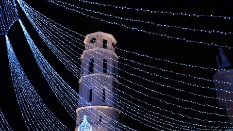 4K Vilnius City tower through Christmas tree Garlands Decoration Stock Footage 122233468