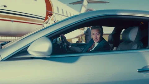 4K VIP Businessman sitting in car puts on sunglasses before boarding private jet Stock Footage