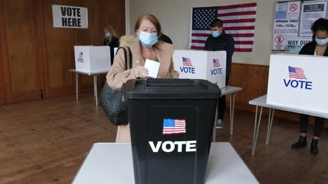 4K: Voter voting at Polling Place for the USA Election. She wears a Face Mask Stock Footage