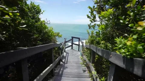 4K walk down to the beach over a rustic boardwalk at the ocean coastline Stock Footage 221427847